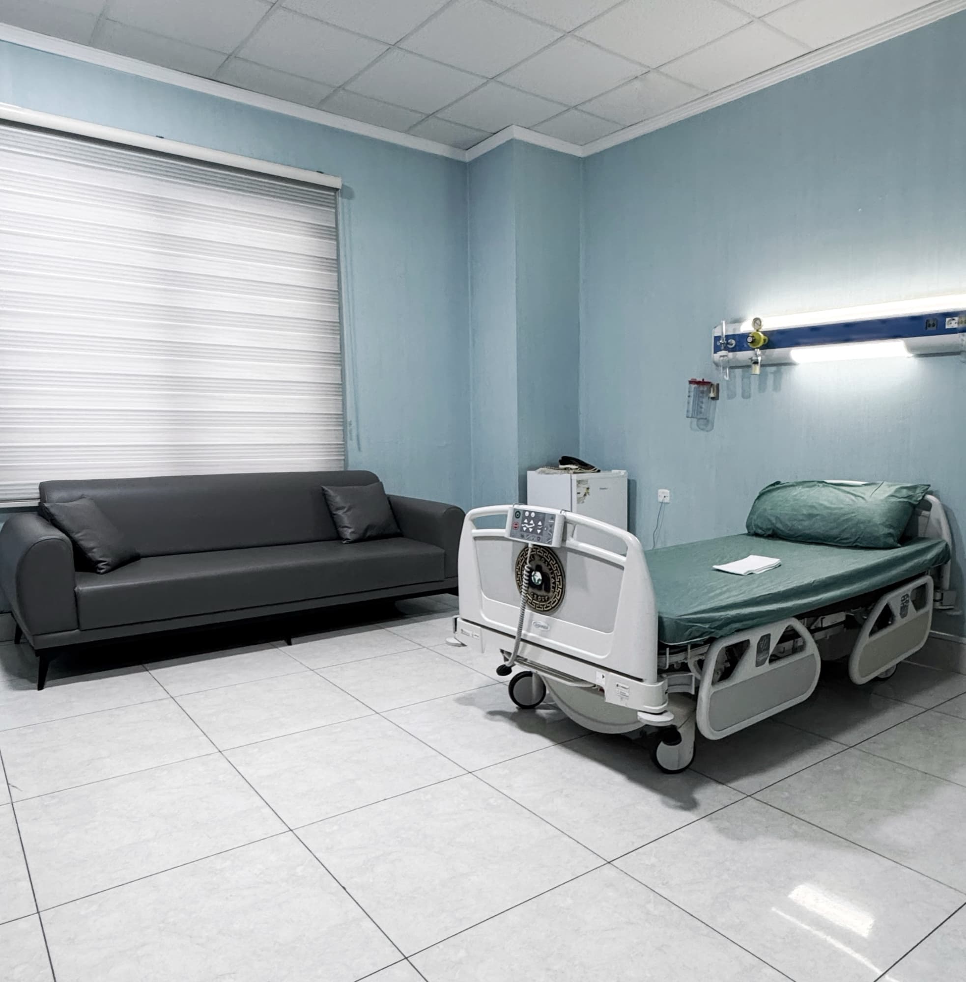 A private patient room with a bed and companion sofa at Kurdistan Hospital